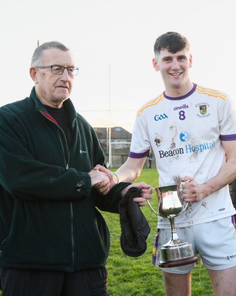Tom Rock presents the cup to Crokes captain Eoin Keys.