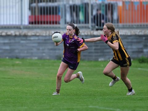 Kilmacud no 9 runs past a tackle, bouncing the ball