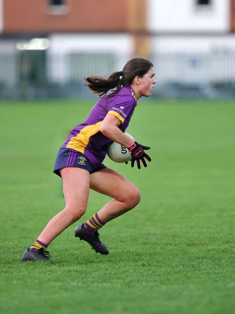Kilmacud no 6 holds the ball and looks up to pass it